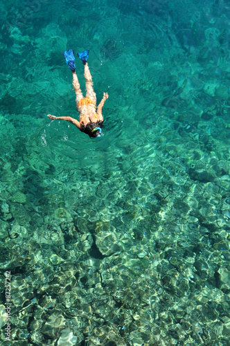 Young lady snorkeling over coral reefs