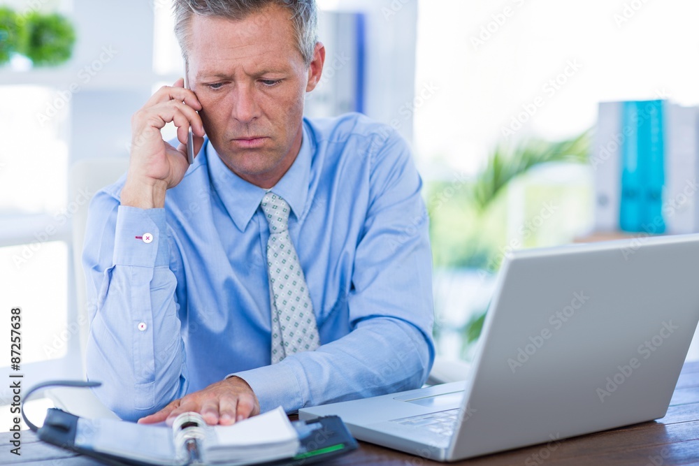 Fototapeta premium Serious businessman having phone call 