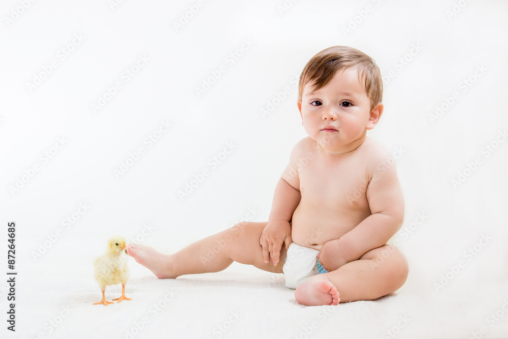 Baby boy in diapers sitting on the floor, playing with cute chick on an isolated white, horizontal orientation. Baby boy in diapers sitting on the floor, playing with cute chick on an isolated white, horizontal orientation.
