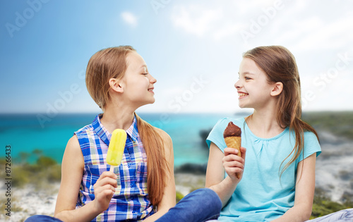 happy little girls eating ice-cream over beach