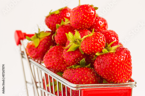 A lot of strawberries at miniature shopping cart