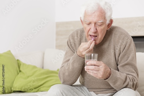 Foto Ill man taking medicine
