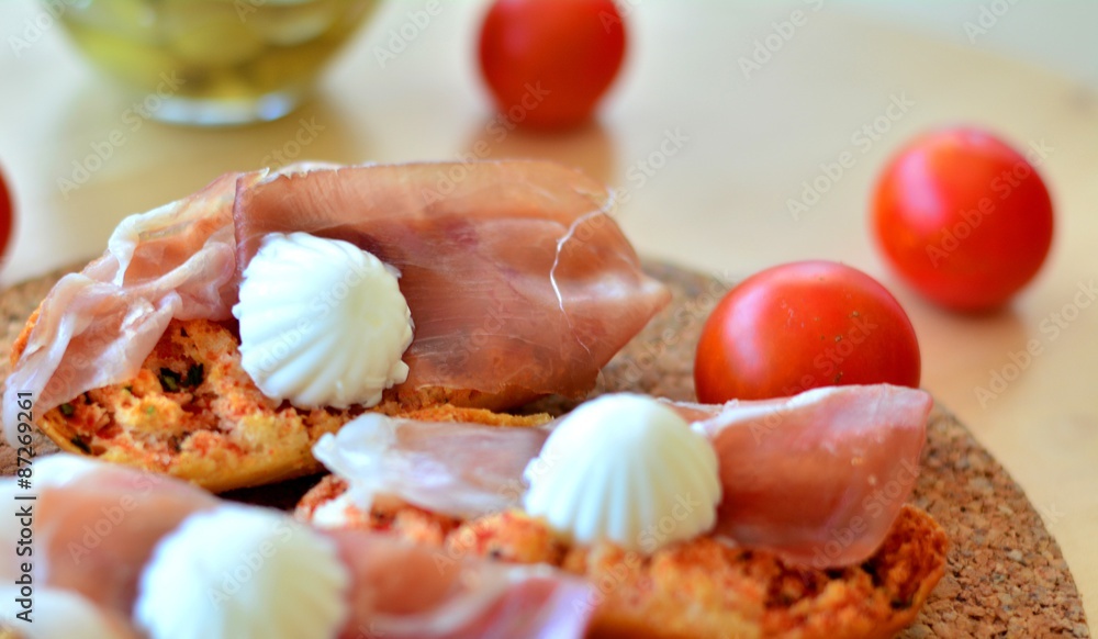 Bruschetta with oregano, prosciutto and mozzarella on a wooden table Bruschetta with oregano, prosciutto and mozzarella on a wooden table