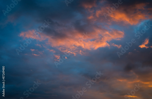 Dramatic sunset sky with orange colored clouds.