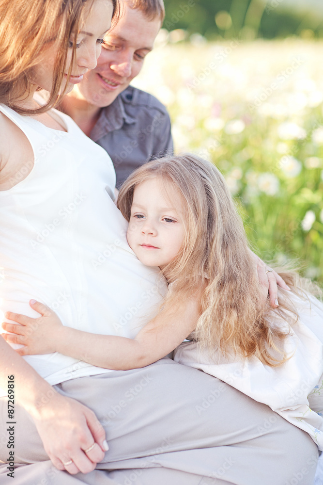 Pretty girl kissing the belly of his pregnant mother on the suns Pretty girl kissing the belly of his pregnant mother on the suns