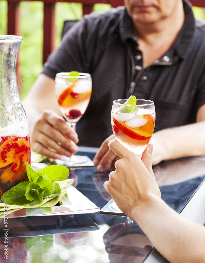 Couple drinking white sangria. White sangria with fruits and berry Couple drinking white sangria. White sangria with fruits and berry