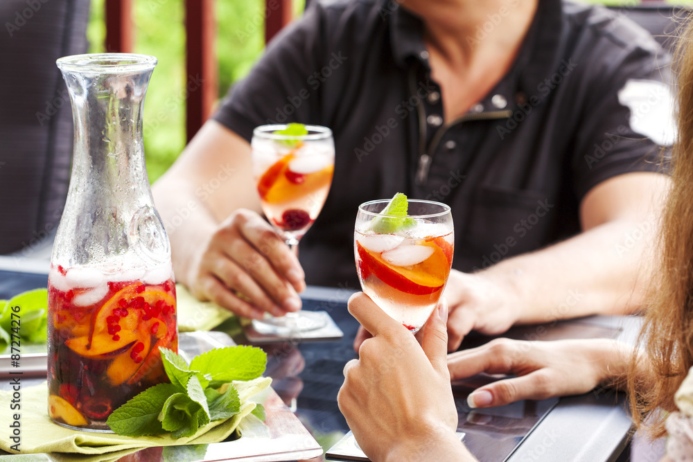 Couple drinking white sangria. White sangria with fruits and berry Couple drinking white sangria. White sangria with fruits and berry