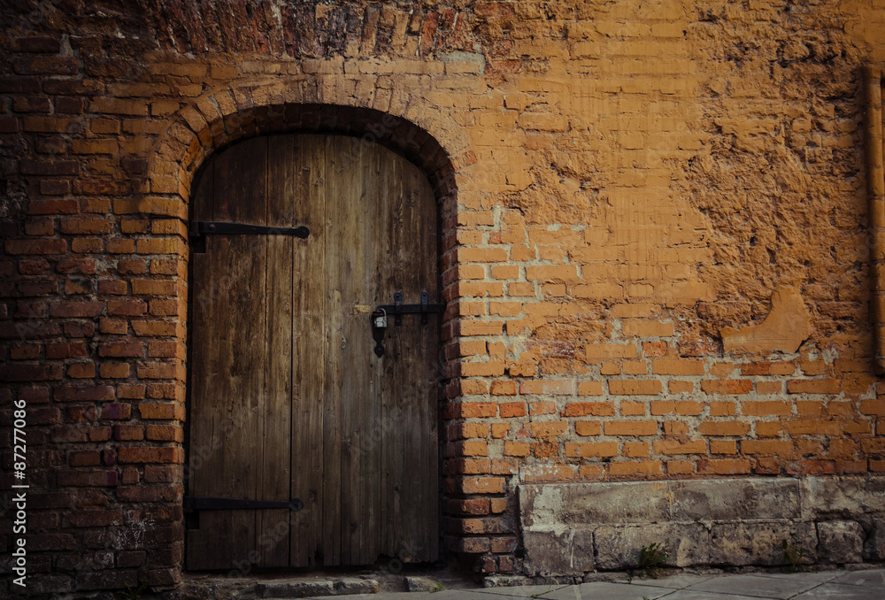 Background: old bricks wall and rusty wooden door