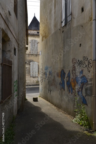 Fototapeta Naklejka Na Ścianę i Meble -  Graffitis sur le mur d'une maison dans un passage étroit 