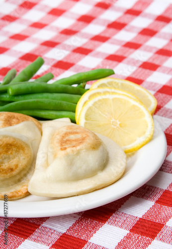 Pierogie Dinner – A plate of pierogies, with green beans and fresh lemon slices.