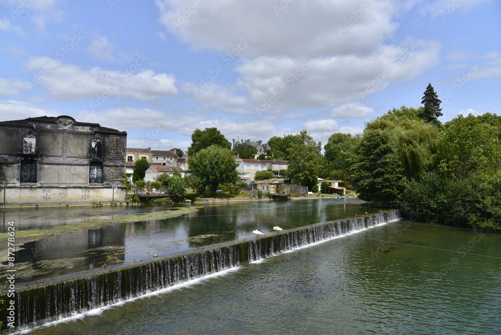 Cascade artificielle avec deux cygnes à son bord dans la Charente à Jarnac