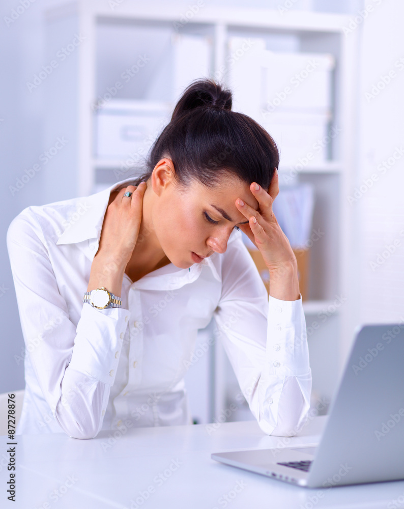 Stressed businesswoman sitting at desk in the office