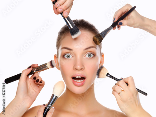 Closeup portrait picture of beautiful woman with brushes photo