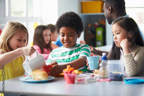 Group Of Children Eating Lunch In School Cafeteria