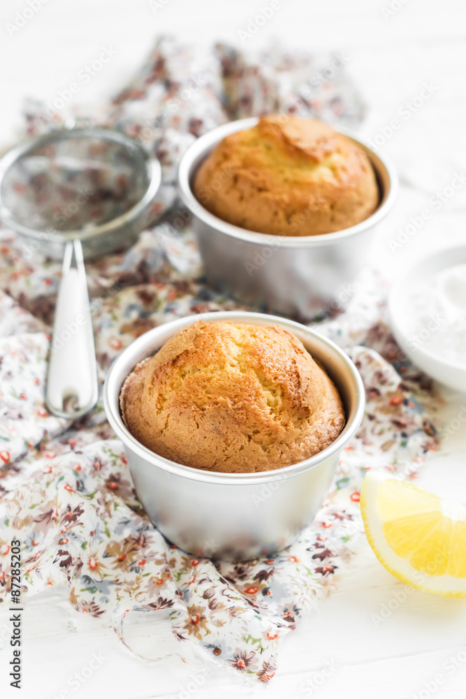 lemon muffins in the baking dish on a light wooden background lemon muffins in the baking dish on a light wooden background