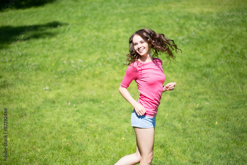 Beautiful girl pink T-shirt fun on the grass Beautiful girl pink T-shirt fun on the grass