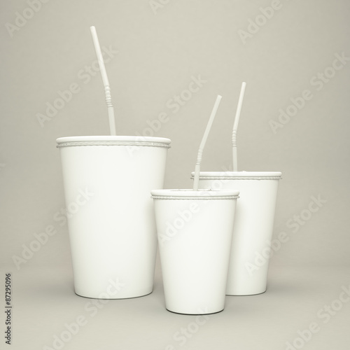 Disposable cup of big volume for beverages with straw on a gray background