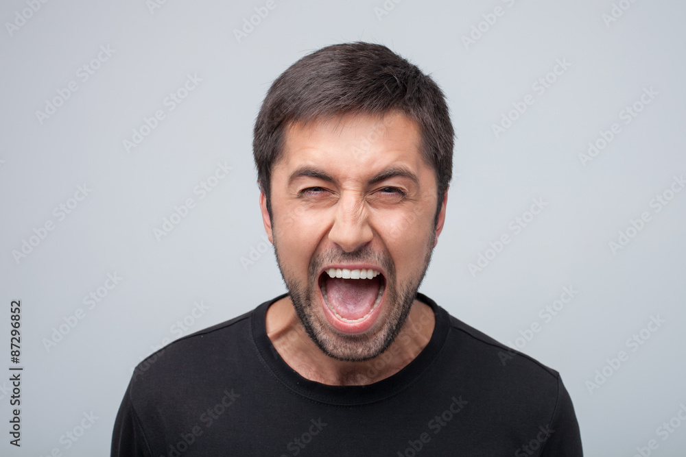Furious young man is evincing negative emotions Furious young man is evincing negative emotions