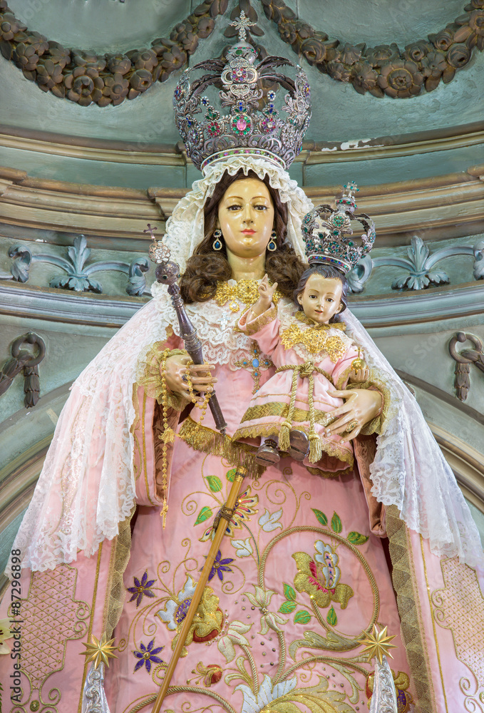 CORDOBA, SPAIN - MAY 26, 2015: The traditional vested statue of Madonna in Church Eremita de Nuestra Senora del Socorro on main altar designed by Alfons Gomes Caballero from 17. cent.
