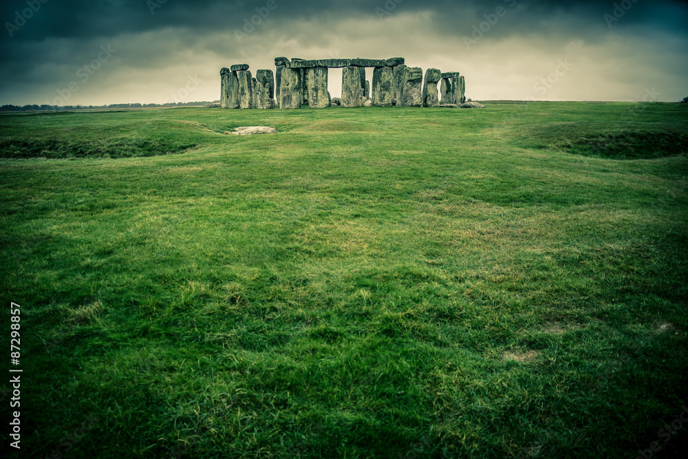 Grass field leading to Stonehenge on a cloudy gray day