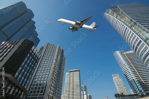 Shot of airplane flying above skyscrapers in City of Bangkok dow