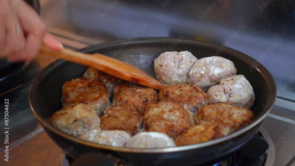 Close up of Female Hands Turning Meat Cutlets in a Frying Pan. Close up of Female Hands Turning Meat Cutlets in a Frying Pan.