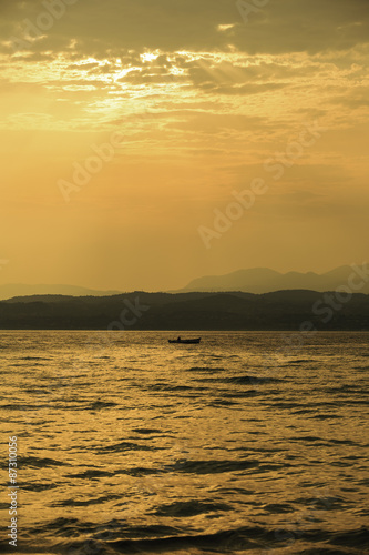 man fishing at vibrant colorful sunset over lake