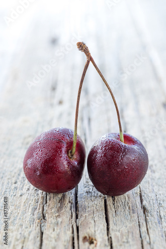 Cherries on wooden table with water drops © Andrei Levitskiy