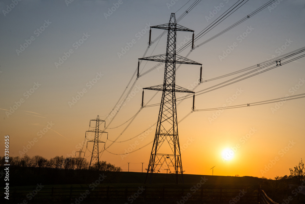 Supplying power at sunset, small wind turbine in the background.