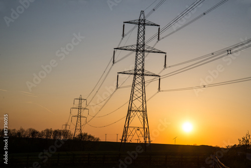 Supplying power at sunset, small wind turbine in the background.