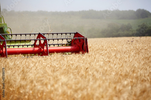 An agricultural combine cutting and harvesting wheat in the fertile farm fields of Idaho.
