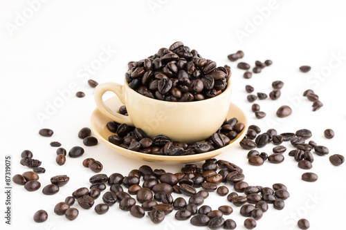 Cup full of coffee beans on on white background