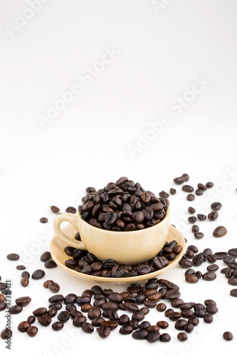 Cup full of coffee beans on on white background