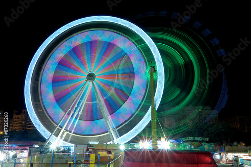 Colorful ferris wheel in motion at night