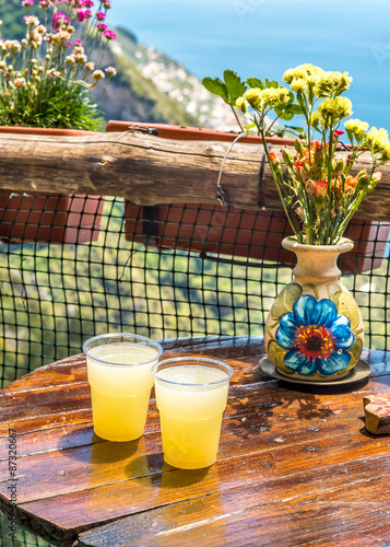 Two glasses of lemon juice  on wood table at hiking trail  Pass of the Gods, Amalfi Coast.