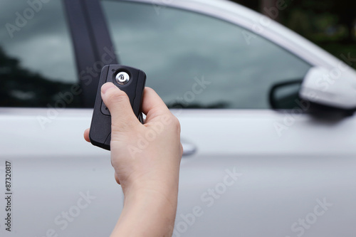 hand using car key to open the car