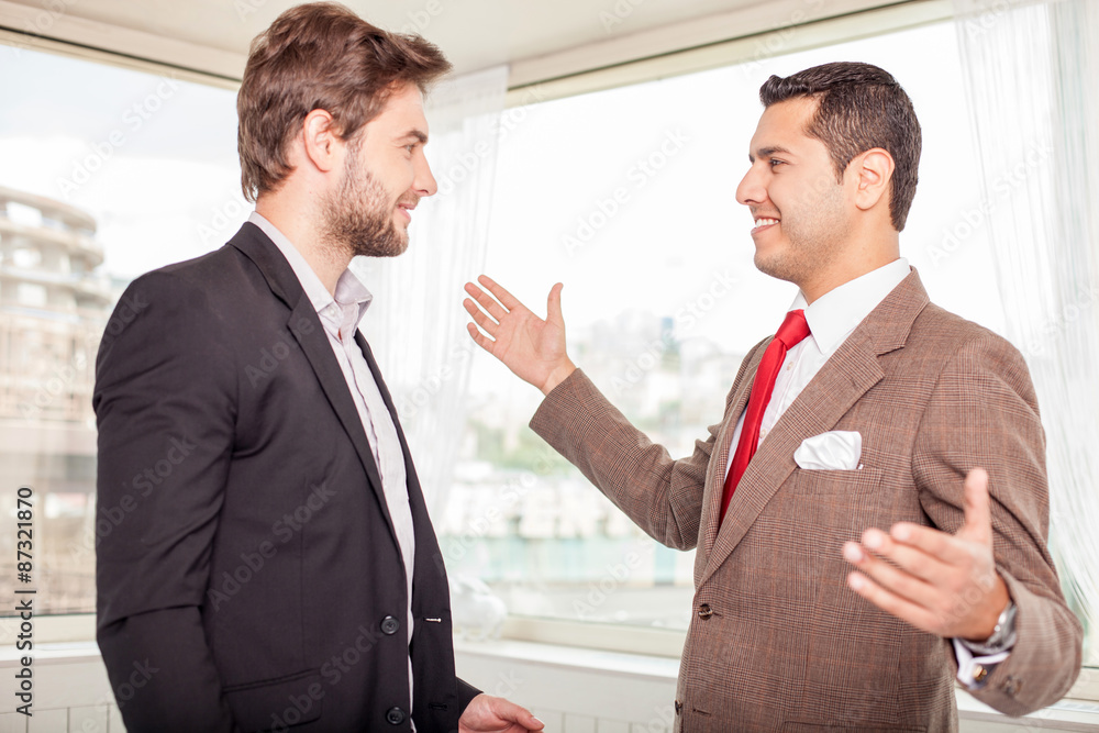 Cheerful young colleagues are greeting each other Cheerful young colleagues are greeting each other