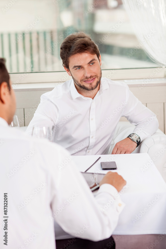 Fototapeta premium Attractive young businessmen have a business lunch in restaurant