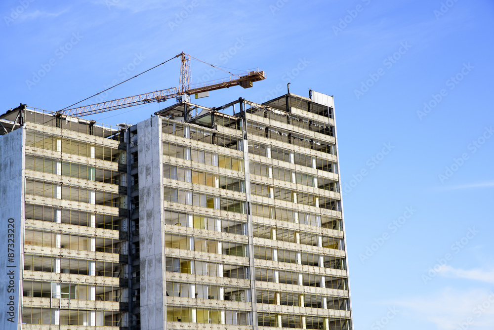 demolition of a skyscraper with a high crane