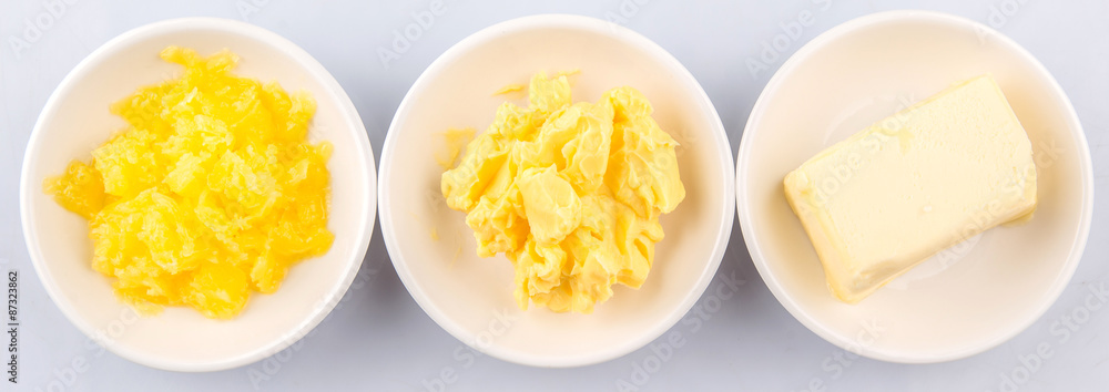 A block of butter, margarine and ghee in white bowls  - obrazy, fototapety, plakaty 