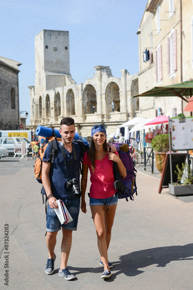 cheerful young couple backpacker traveling and sighseeing through europe during summer