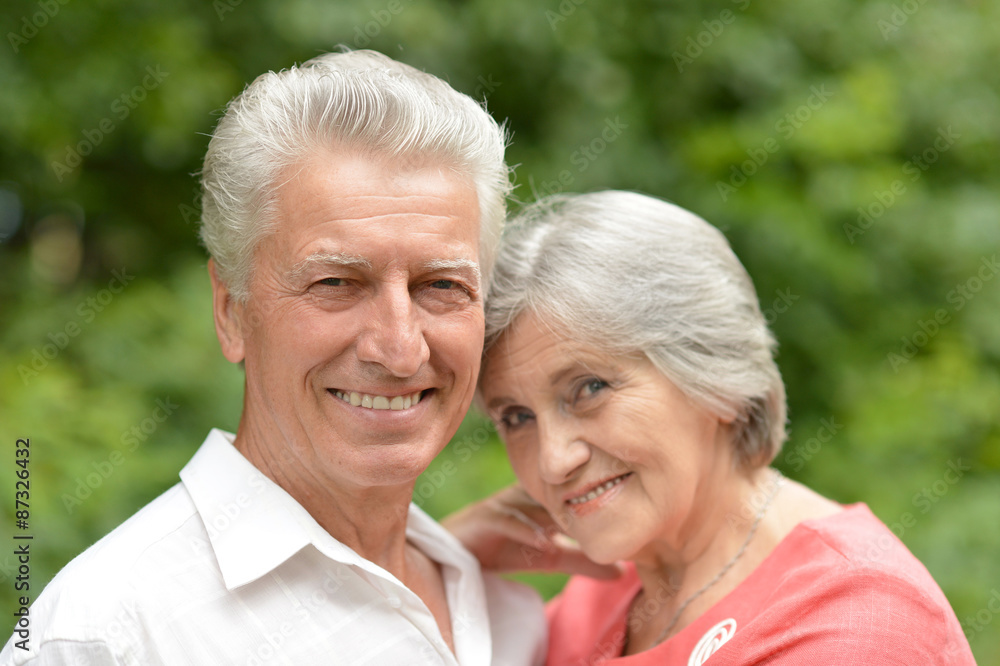 Senior couple sit on a ground in summer forest Senior couple sit on a ground in summer forest