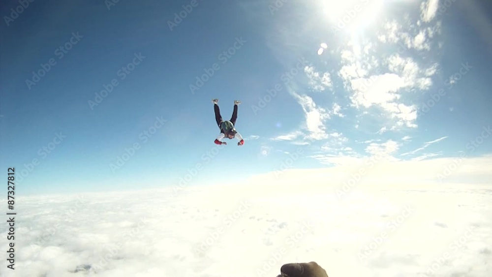 Skydiver through a wonderful blue sky with clouds.