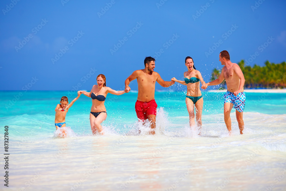 group of happy friends running together on tropical beach group of happy friends running together on tropical beach