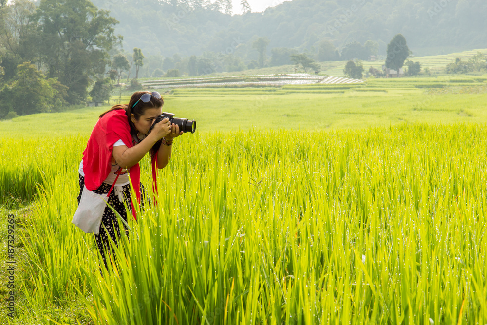 Asian women take a photo green terraced rice field in Mae Klang Luang , Mae Chaem, Chiang Mai, Thailand Asian women take a photo green terraced rice field in Mae Klang Luang , Mae Chaem, Chiang Mai, Thailand
