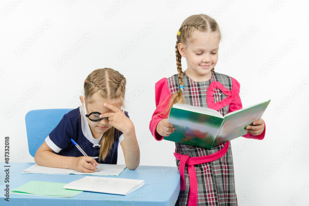 The teacher reads the student assignment The teacher reads the student assignment