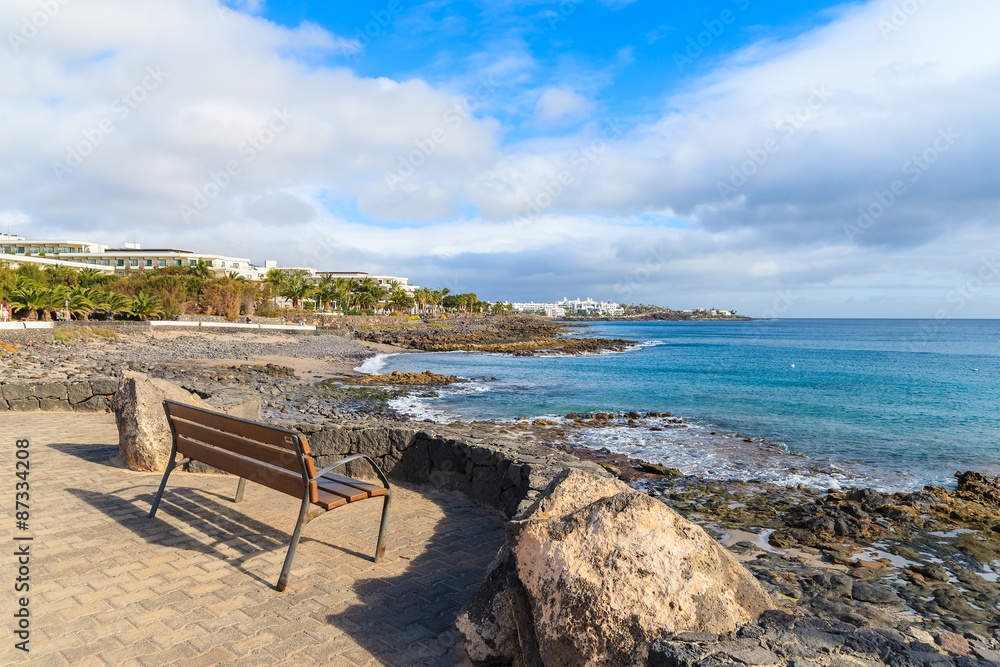 Bench on promenade along ocean coast in Playa Blanca, Lanzarote, Canary Islands, Spain