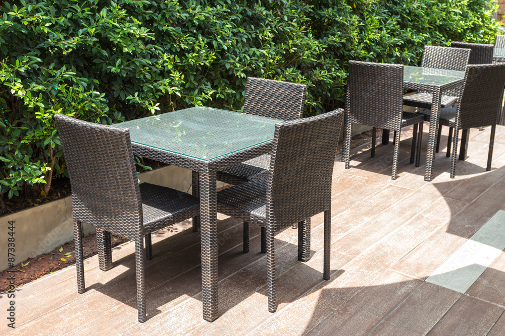 Fototapeta premium Cafe tables and chairs outside with green plant