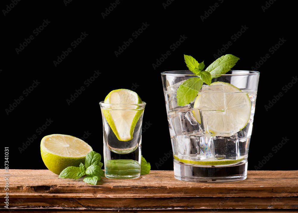 alcoholic drink with lemon and ice on a old wooden table alcoholic drink with lemon and ice on a old wooden table