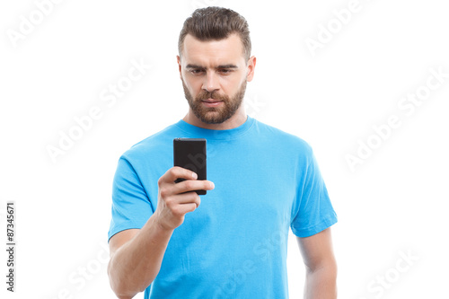 Handsome man with beard holding mobile phone 